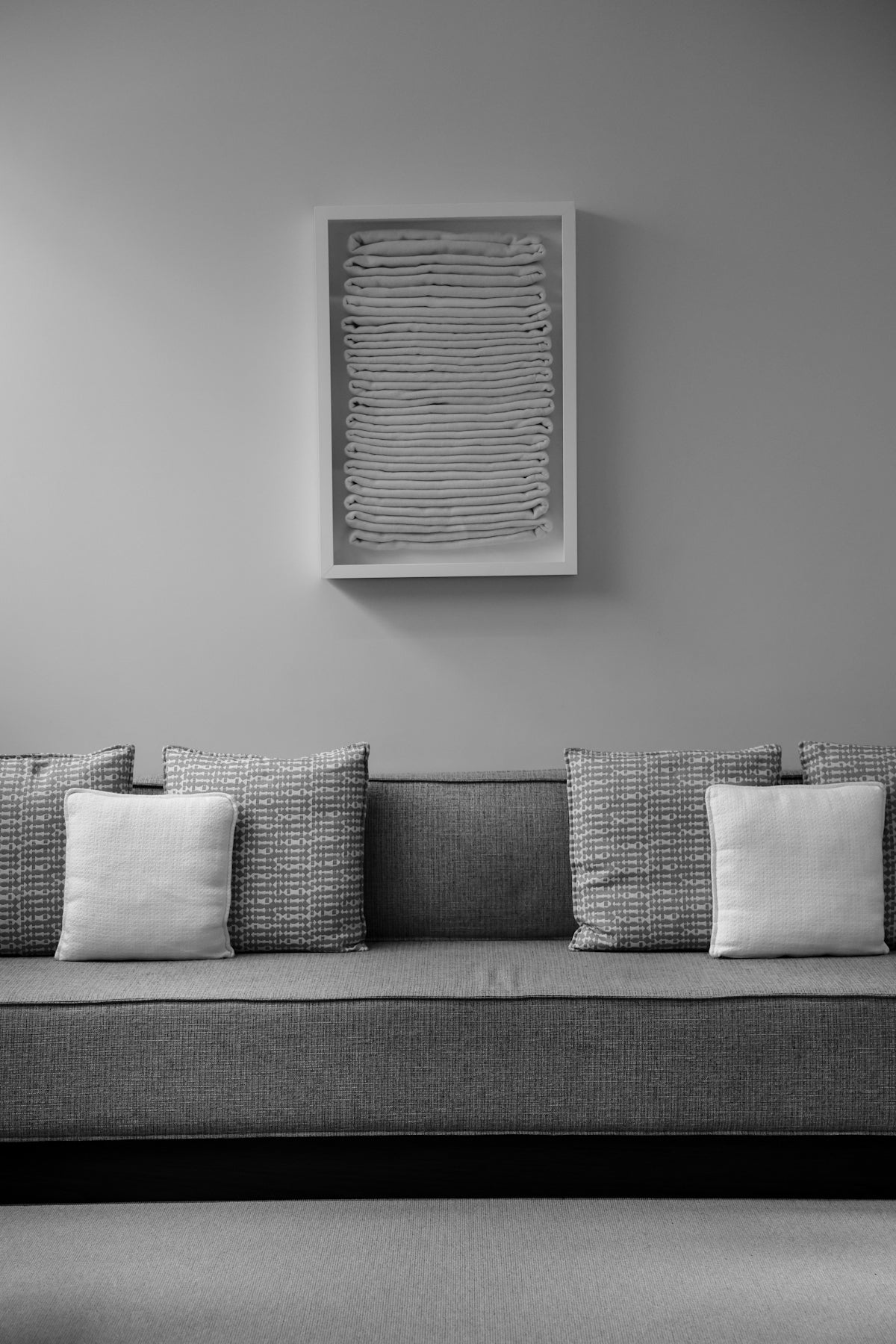 A couch with pillows and artwork on the wall.