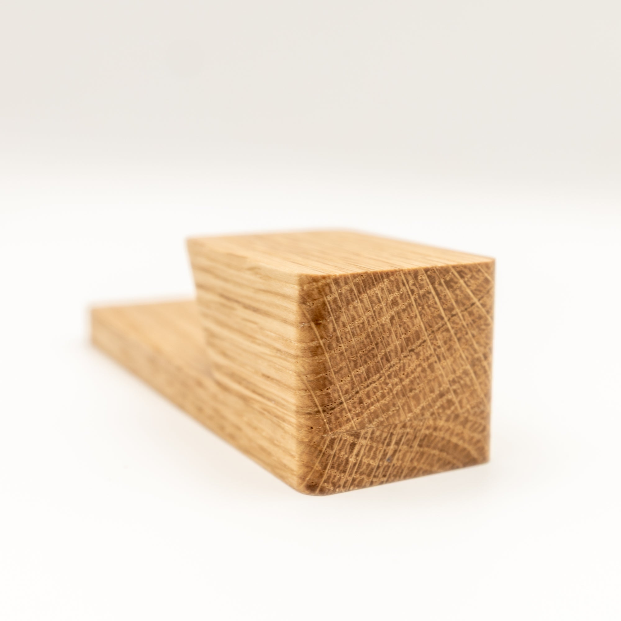 Handmade oak adhesive wall hook with natural grain detail close-up