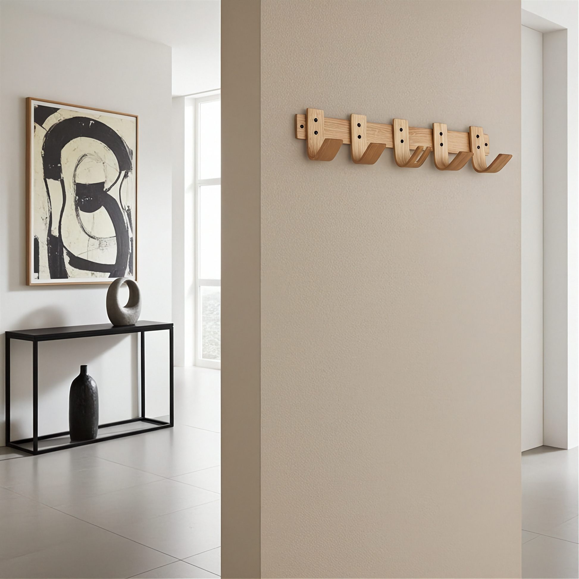 Modern interior with abstract art, black console table, and wooden wall hooks.